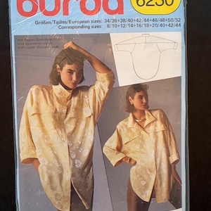 May include: A Burda 6230 sewing pattern package. The package shows a woman in a light yellow floral shirt. Text includes size details and the words "raglan shoulder pads". Sizes are given in European and corresponding sizes.