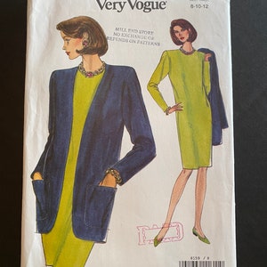 Op de afbeelding: Een naaipatroon voor een jurk en een jas. Het patroon is voor maten 8-10-12. Het patroon is van Very Easy Very Vogue en het patroonnummer is 8159. Het patroon toont een vrouw die een groene jurk met een blauwe jas draagt en een vrouw die een groene jurk draagt.