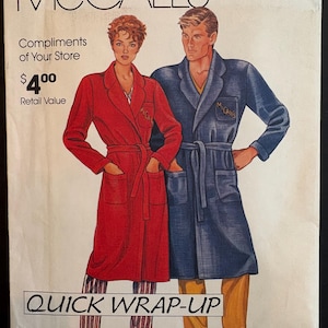 May include: A McCall's sewing pattern envelope titled Quick Wrap-Up featuring illustrations of two people wearing long-sleeved, belted robes with lapels and patch pockets. The red robe is worn over striped pants, and the blue robe over yellow pants.