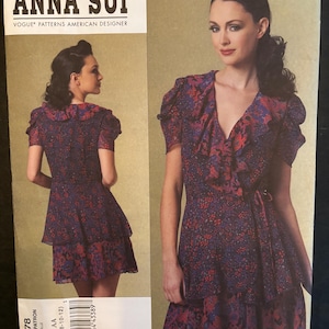 May include: Vogue Patterns American Designer Anna Sui sewing pattern V1178. The pattern features a dress with a ruffled neckline and tiered skirt. The dress is shown in a floral print fabric with red, blue, and purple hues. Sizes AA (6-8-10-12) are included.