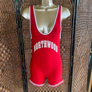 May include: Red wrestling singlet with white trim and the word "NORTHWOOD" printed in white on the front.