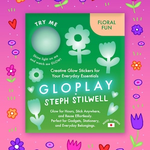 May include: A green package of GloPlay glow-in-the-dark stickers with a floral theme. The package has a pink and purple border with flower and heart illustrations. The text on the package says "Try Me" and "Floral Fun".