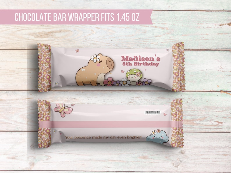 K&ouml;nnte beinhalten: Ein rosa-wei&szlig;er Schokoladenriegel-Wrapper mit einem Cartoon-Capybara- und Pilz-Design. Der Wrapper lautet "Madison's 8th Birthday" und "Your presence made my day even brighter!"