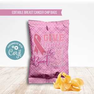 May include: A pink chip bag with a plaid pattern and a pink ribbon, a boot, and the words "GIVE cancer The Boot" in white and pink. The text "Breast Cancer Awareness" is also present. A pile of chips is in front of the bag.