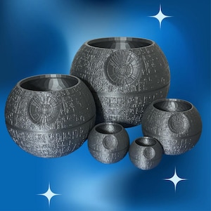 May include: A collection of gray, spherical planters, resembling the Death Star from Star Wars. The planters vary in size, with textured surfaces and a circular design element. The background is a gradient of blue.