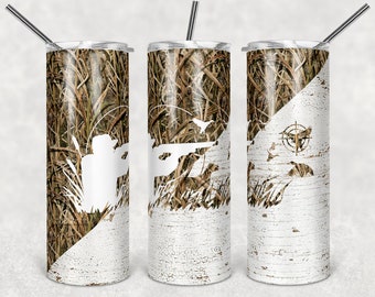 Könnte beinhalten: Drei Edelstahlbecher mit Tarnmuster und einem weißen, abgenutzten Holzdesign. Die Becher zeigen eine Silhouette eines Jägers mit einer Waffe und fliegenden Enten.