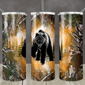 May include: Three stainless steel tumblers with a black bear walking through a forest scene with a camouflage background. The tumblers are all the same design and have a straw in each.