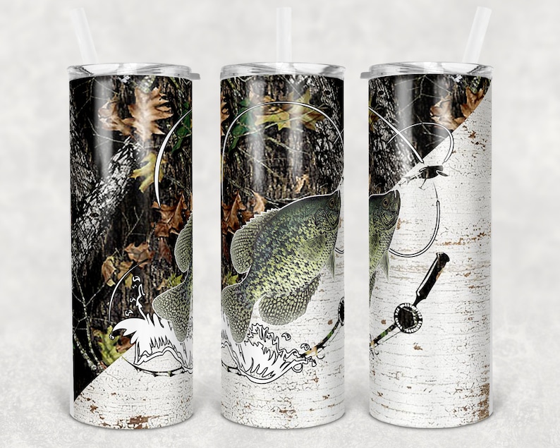 May include: A set of three stainless steel tumblers with a camouflage and birch bark design. The tumblers feature a black and white illustration of a fish with a fishing line and lure.