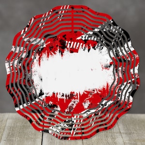 May include: A circular design in red and black with a white centre. The design has a grunge look with black and white paint splatters and red stripes.