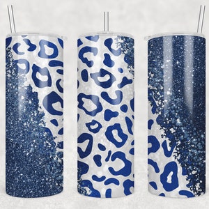 Pode incluir: Três copos de aço inoxidável com tampas e canudos. Os copos são decorados com um design de estampa de leopardo azul e branco. O design apresenta um fundo branco com manchas de leopardo azuis.
