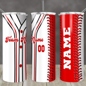 Pode incluir: Três copos de aço inoxidável com tema de beisebol. Os copos são brancos com detalhes vermelhos e pretos. Um copo tem o texto "Team Name", outro tem o texto "Name" e o terceiro tem um design de costura de beisebol.
