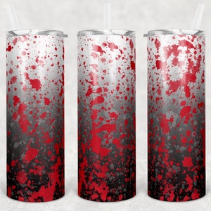 May include: Three stainless steel tumblers with a red and black splatter paint design. The tumblers are tall and slender with a lid and straw.