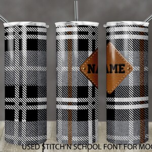 Könnte beinhalten: Drei Edelstahlbecher mit einem schwarzen, weißen und braunen Karomuster. Der mittlere Becher hat einen braunen Lederfleck mit dem Wort "NAME" darauf.