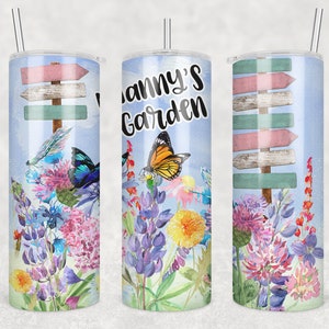 May include: A stainless steel tumbler with a blue background and a floral design. The tumbler has a straw and the text "Granny's Garden" is printed on the side.