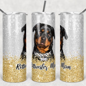 Puede incluir: Un vaso de acero inoxidable con fondo de purpurina dorada y una imagen de un perro Rottweiler. El texto "Rottweiler Mom" está impreso en el vaso.