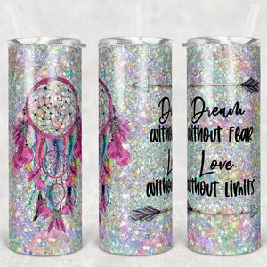 Op de afbeelding: Drie roestvrijstalen bekers met een glitterachtige afwerking. De beker links heeft een roze en blauwe droomvanger met veren. De beker in het midden heeft de tekst "Dream without fear, Love without limits" met een pijl. De beker rechts heeft de tekst "Dream without fear, Love without limits" met een pijl.