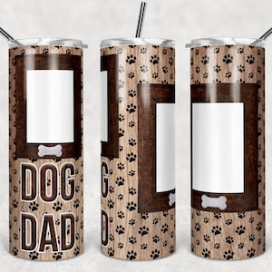 May include: A stainless steel tumbler with a brown woodgrain and paw print design. The tumbler has a white photo frame with a bone graphic and the text "DOG DAD".