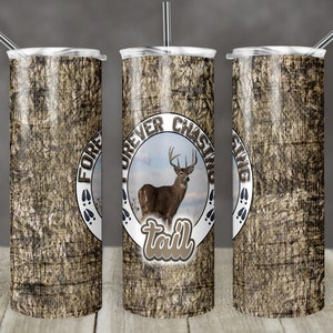 May include: A stainless steel tumbler with a camouflage pattern and a white circle with the text "Forever Chasing Tail" and a silhouette of a deer inside.