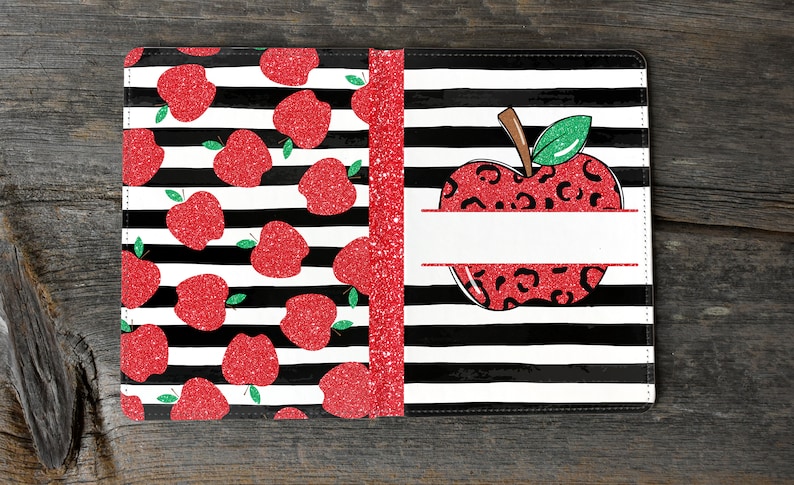 May include: A black and white striped notebook cover with a red glitter apple design. The apple has a leopard print pattern and a blank space for personalization.