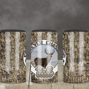 May include: Three stainless steel tumblers with a camouflage pattern and a white circle with the text "Forever Chasing Tail" and a cartoon image of a white-tailed deer.