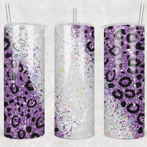 Pode incluir: Três copos de aço inoxidável com tampas e canudos. Os copos são decorados com um design de estampa de leopardo de glitter roxo e preto.