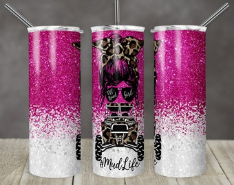 May include: Pink and white glitter tumbler with a graphic of a woman with a leopard print bow in her hair, sunglasses, and an off-road vehicle. The text "Off Road Girl" and "#MudLife" are on the tumbler.