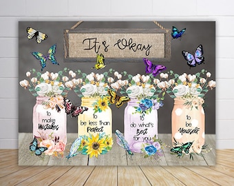 May include: Four mason jars with floral arrangements and butterflies. Each jar has a different inspirational quote: "to make mistakes", "to be less than perfect", "to do what's best for you", and "to be yourself". The jars are on a gray background with a sign that says "It's Okay".