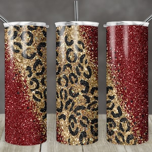 Pode incluir: Três copos de aço inoxidável com um design de glitter vermelho e dourado. O design de glitter apresenta um padrão de estampa de leopardo preto.