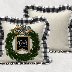 May include: Two decorative throw pillows with black and white buffalo check trim. One pillow features a green wreath with a brown bow and a sign that reads "The Dodd Family".