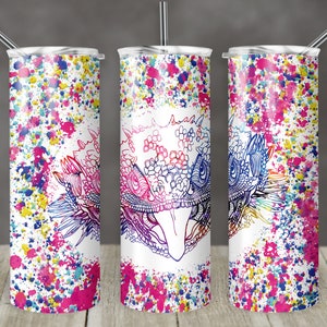 Puede incluir: Tres vasos de acero inoxidable con fondo blanco y salpicaduras de pintura de colores. El vaso del centro presenta un dibujo de línea detallado de la cabeza de un lagarto con un degradado de colores arcoíris.