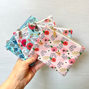 Puede incluir: Cinco peque&ntilde;as bolsas con cremallera con estampado floral y la frase "oh for fuck's sake" repetida en cada bolsa. Las bolsas son de varios tonos de azul y rosa.