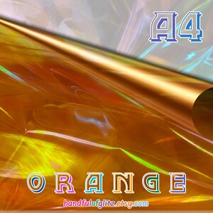 Könnte beinhalten: Orangenes holografisches Folienpapier mit einer hochgebogenen Ecke, das einen Blick auf eine hellere, schillernde Schicht darunter freigibt. Der Text "A4" befindet sich in der oberen rechten Ecke und das Wort "ORANGE" unten.