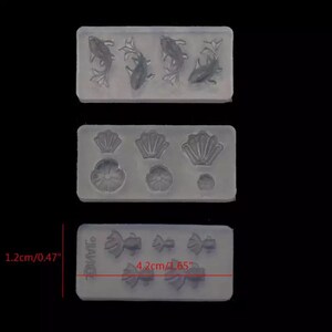 May include: Three silicone molds for crafting. The first mold has four fish designs. The second mold has three seashell designs and three flower designs. The third mold has three bow designs and three fish designs. The molds are 4.2 cm by 1.2 cm.