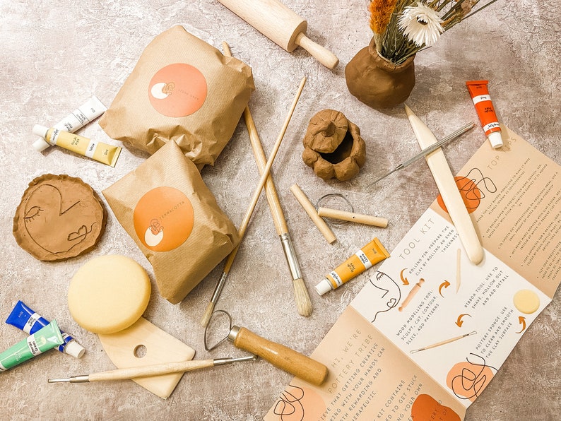 May include: A pottery tool kit with various supplies. Includes paint tubes, brushes, clay, a rolling pin, and a tool kit guide. The kit contains clay, tools, and instructions for creating pottery. The kit is designed for therapeutic and rewarding creative experiences.