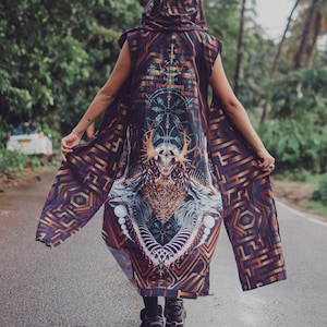 May include: A hooded, sleeveless cloak with a complex geometric and artistic design in shades of brown, purple, and gold. The cloak features a detailed central graphic of a figure with antlers and intricate patterns, and a maze-like design on the sleeves.
