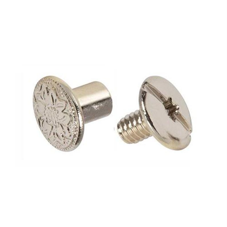 May include: Two silver-colored metal screws. One screw has a flat, round head with a floral design. The other screw has a slotted head and a threaded shaft. Both screws are on a white background.