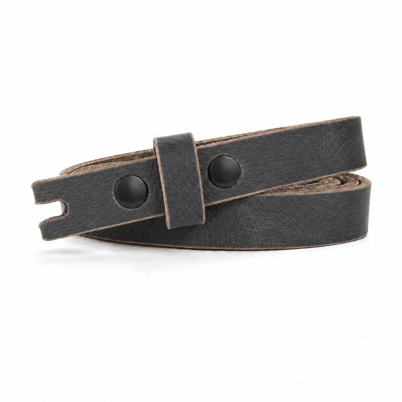 May include: A dark charcoal gray leather strap coiled into a circle. The strap features a matte finish, a single sliding leather keeper, and two black metal snap fasteners. One end of the strap has a notched cutout detail for secure fastening.