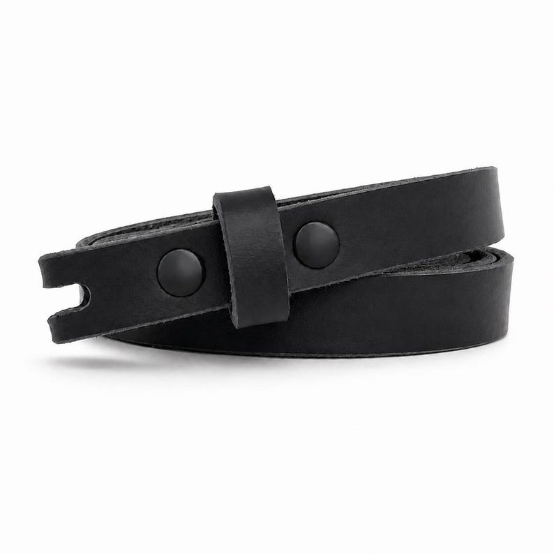 May include: A black leather belt featuring a smooth matte finish, a single leather keeper loop, and two matching black metal snap fasteners. The end of the strap has a notched cutout detail, and the belt is coiled into a circular shape.