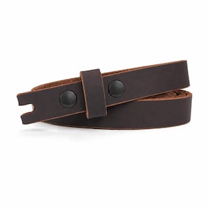 May include: A dark brown leather belt featuring a smooth matte finish, a single leather keeper loop, and two black metal snap fasteners. The end of the belt strap has a notched cutout detail, and the edges show the natural tan color of the leather.