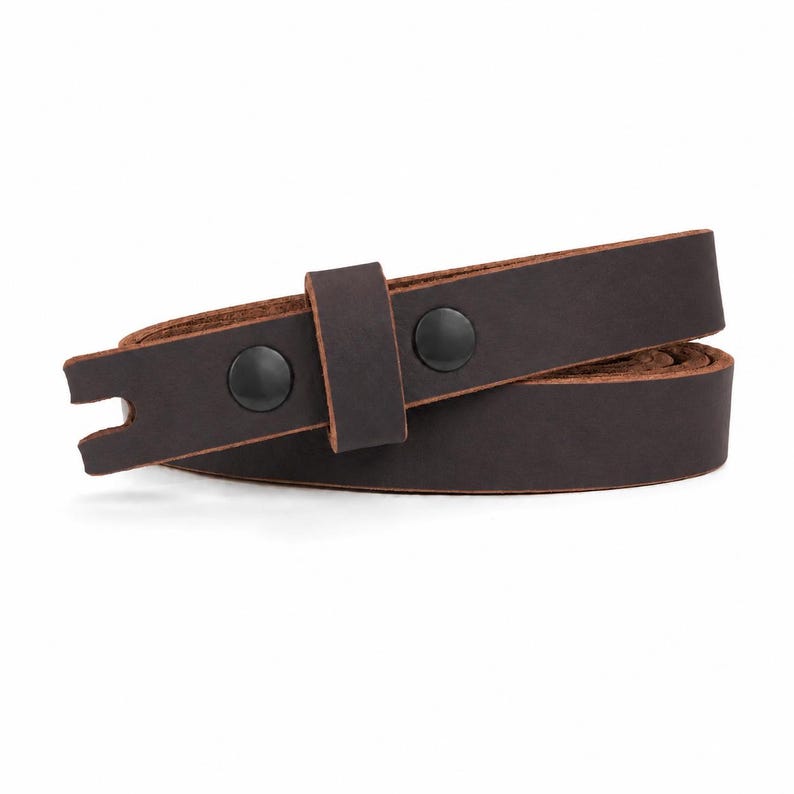 May include: A dark brown leather belt featuring a smooth matte finish, a single leather keeper loop, and two black metal snap fasteners. The end of the belt strap has a notched cutout detail, and the edges show the natural tan color of the leather.