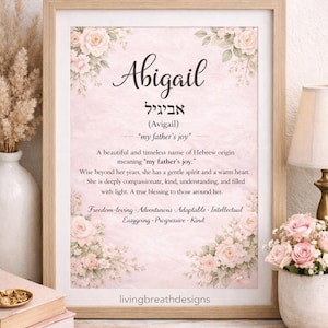 May include: A framed print with the name "Abigail" in a decorative font, accompanied by Hebrew text and the phrase "my father's joy." The design incorporates floral elements in pink and cream hues, with "livingbreathdesigns" at the bottom.