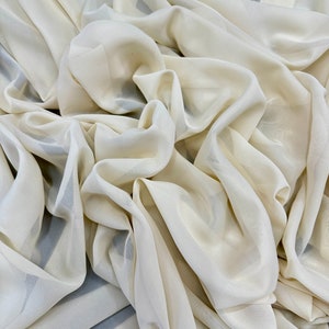 May include: A close-up of a cream-colored sheer fabric, showing its texture and drape.
