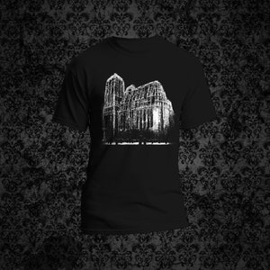 May include: Black t-shirt with a white graphic print of a building with a gothic architecture style.