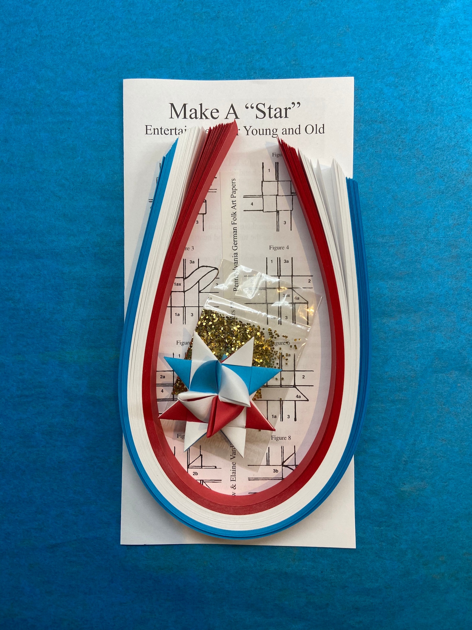 Make a Star Kit - 100 Strips - Red, White and Blue. Includes sample star, instructions and glitter pack. Makes 25 stars.