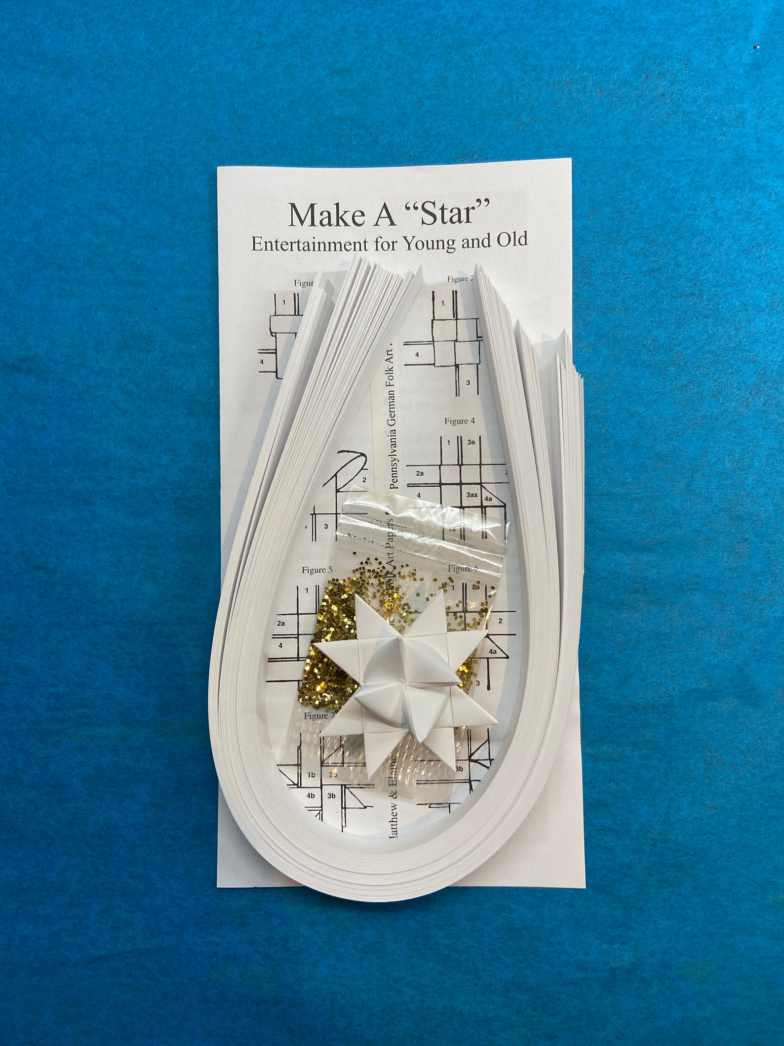 Make a Star Kit - 100 Strips - White. Includes sample star, instructions and glitter pack. Makes 25 stars.