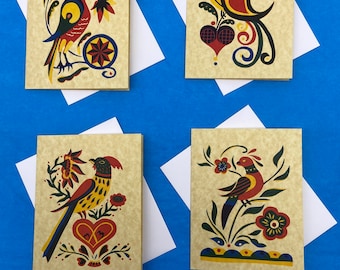May include: Four greeting cards with bird illustrations. Each card features a different colorful bird design on a beige background, with white envelopes. The birds are depicted with intricate details and surrounded by floral elements.