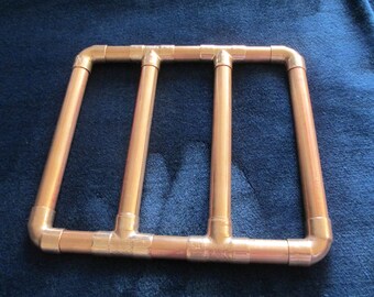 May include: A copper-colored metal frame made of pipes, with three vertical sections and a rectangular shape.