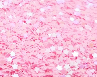 May include: Pink glitter with a star shape. The glitter is iridescent and has a light pink base.