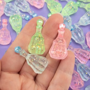 May include: A collection of small, iridescent glass bottles with glitter inside. The bottles are in various shades of pink, green, and blue.