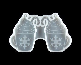 May include: White silicone mold of two hot chocolate mugs with whipped cream and candy canes. The mugs have snowflakes on them.